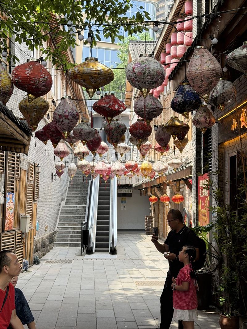 A lane of Eighteen Stairs hung with colourful lanterns, with an escalator and stairs