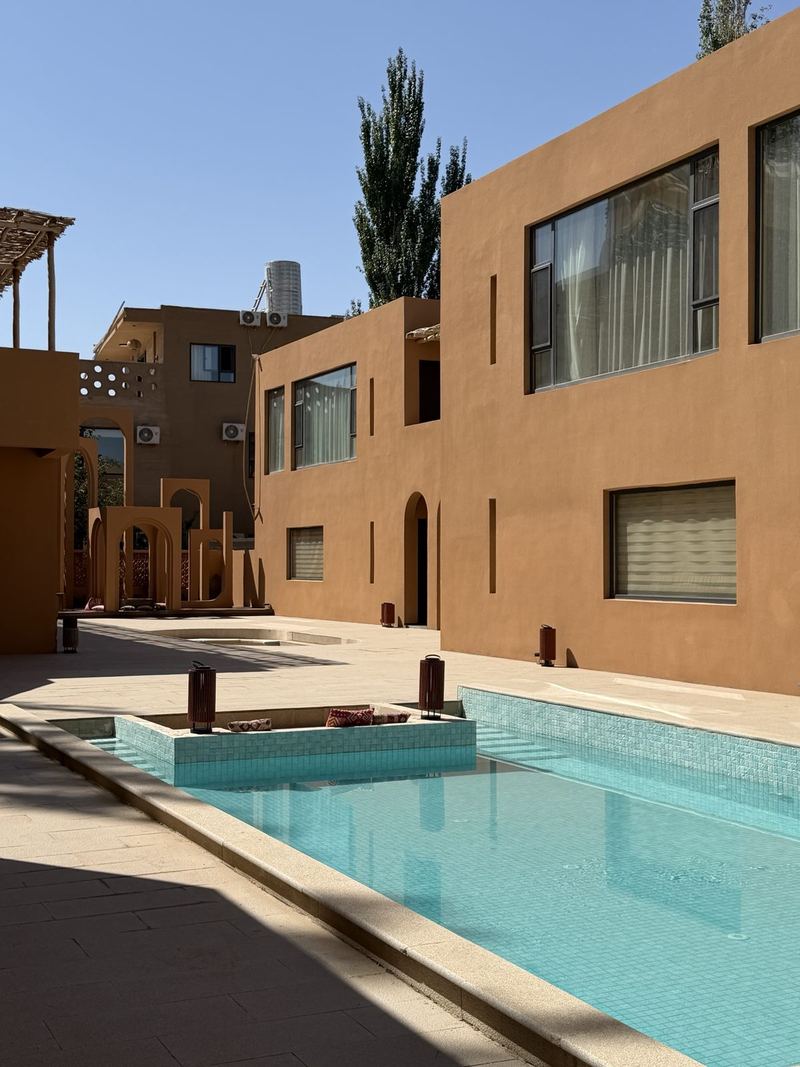 Turquoise pool between ochre walls at the Boman Oasis Resort, Dunhuang
