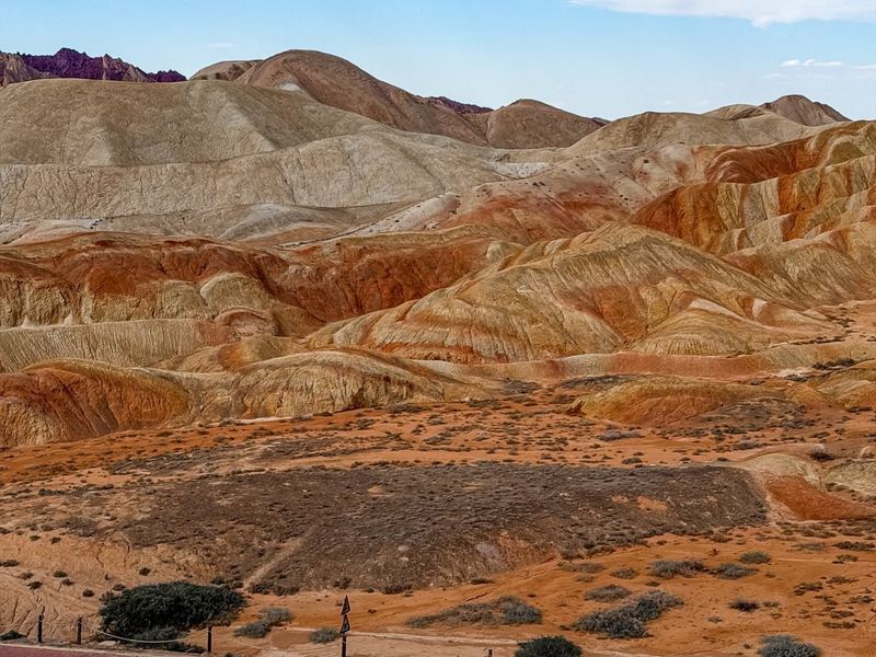 Rolling red, cream and orange hills of the Zhangye Danxia under a blue sky
