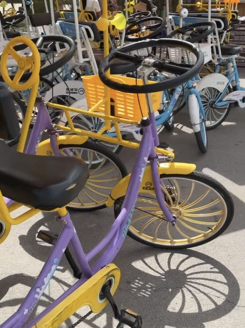 Pedal surrey bikes with striped canopies lined up for rent in Zhangye