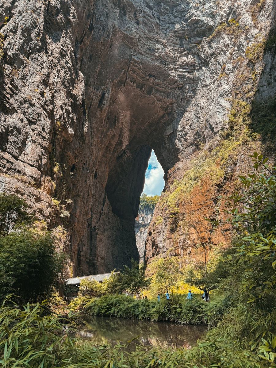 The Tianlong natural bridge in Wulong with a pond and bamboo in front