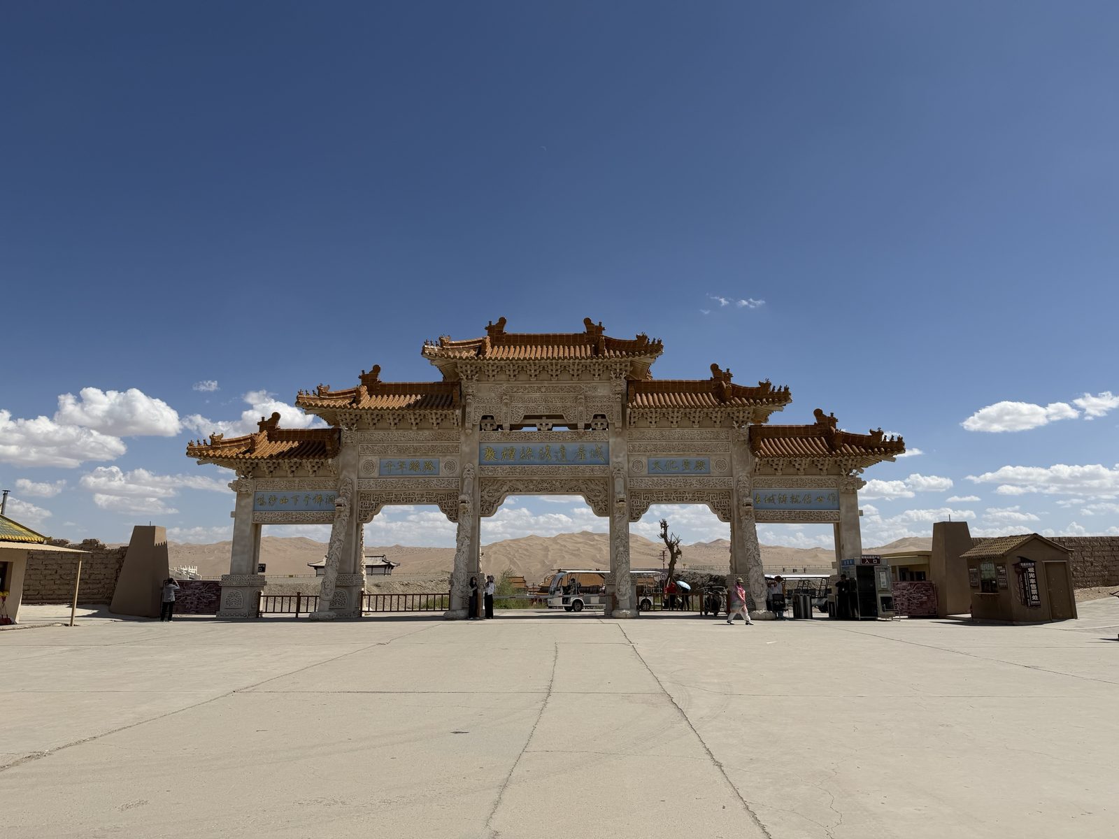 Entrance gate of the Dunhuang Silk Road Heritage City with sand dunes behind