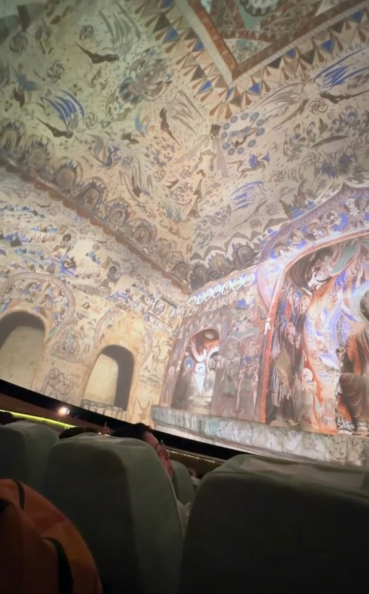 A painted cave ceiling projected all around the dome theatre at the Mogao visitor centre